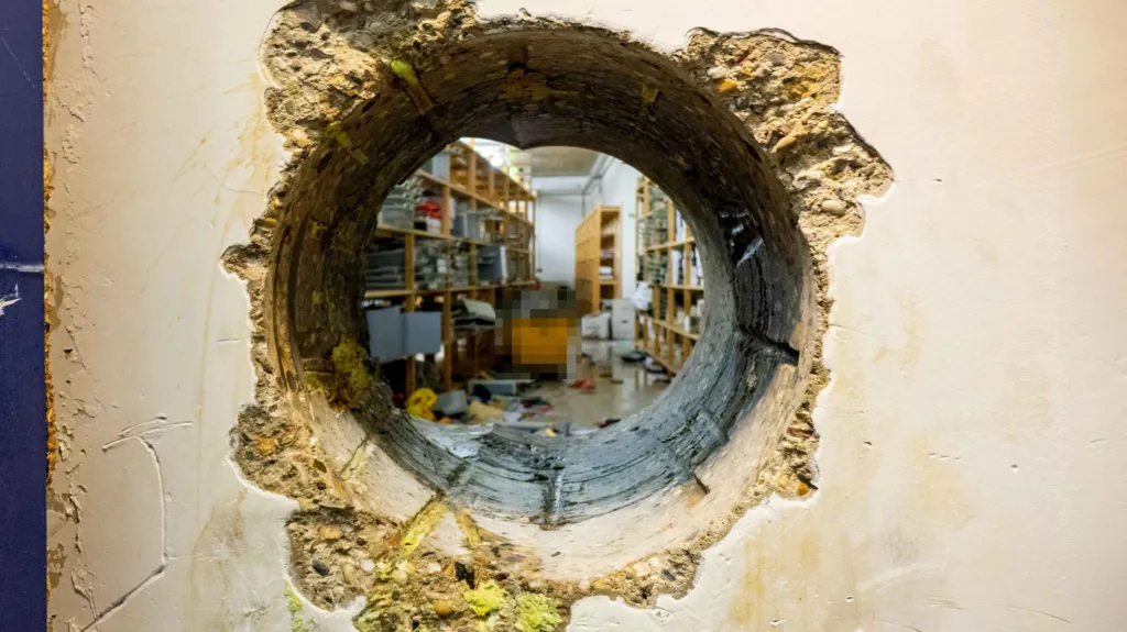 A hole in a wall created by a large drill