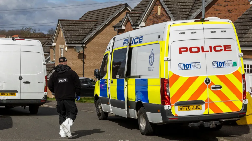 A police van and a police officer outside Murrell's home in April 2023.