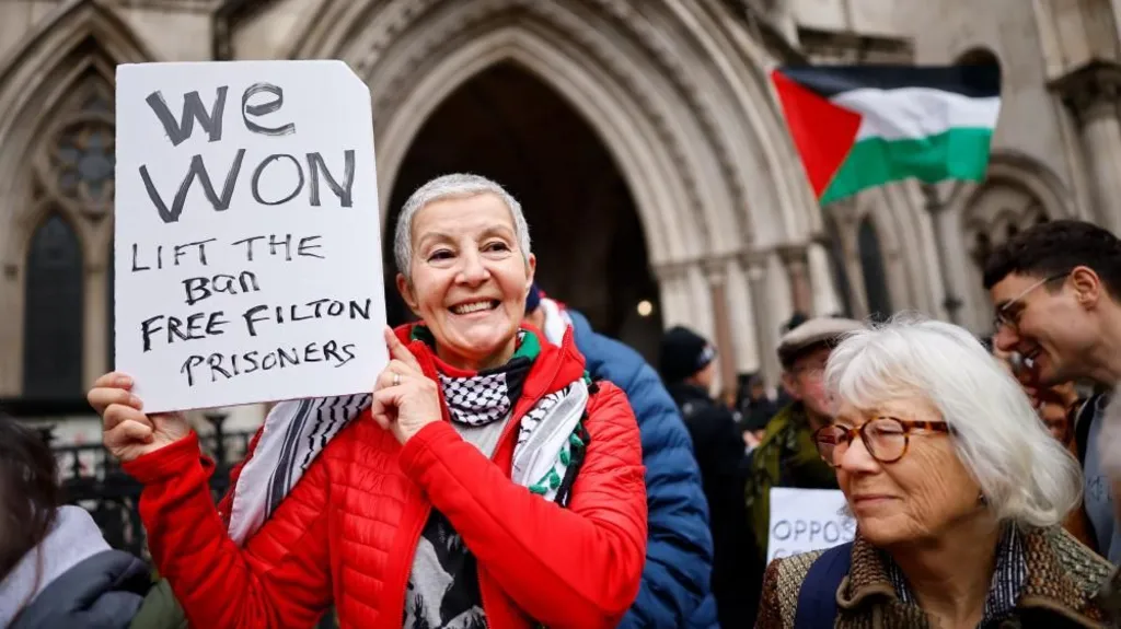 A woman holds a sign saying "We Won" outside the court
