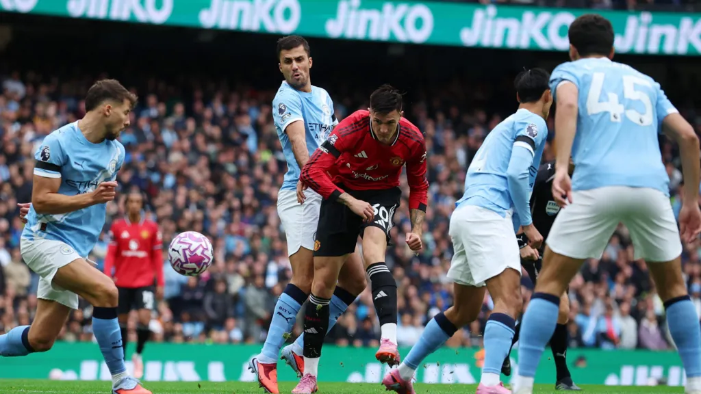 Manchester City's Ruben Dias in action with Manchester United's Benjamin Sesko with several other Manchester City players in view