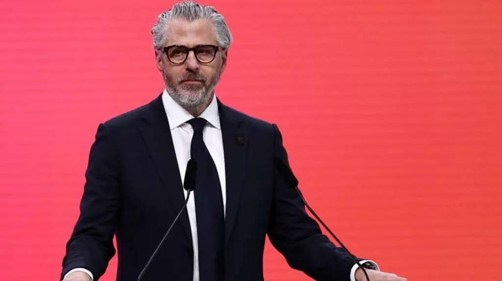 Casey Wasserman speaking from behind a podium