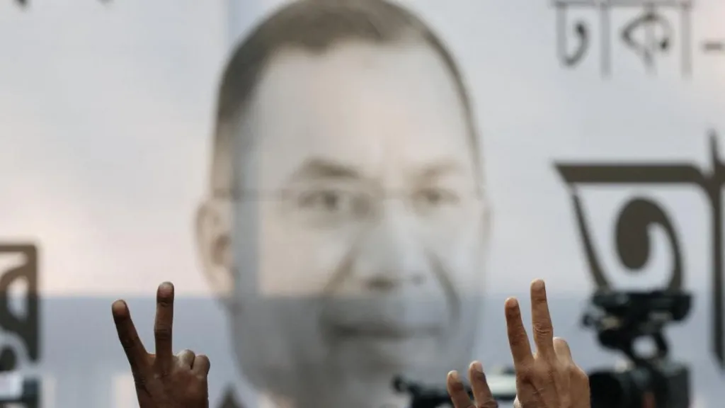 Supporters of the Bangladesh Nationalist Party (BNP) show a victory sign in front of a banner with Tarique Rahman’s photo, as the results project BNP's victory in the 13th general election, in Dhaka, Bangladesh, February 13, 2026. REUTERS/Mohammad Ponir Hossain