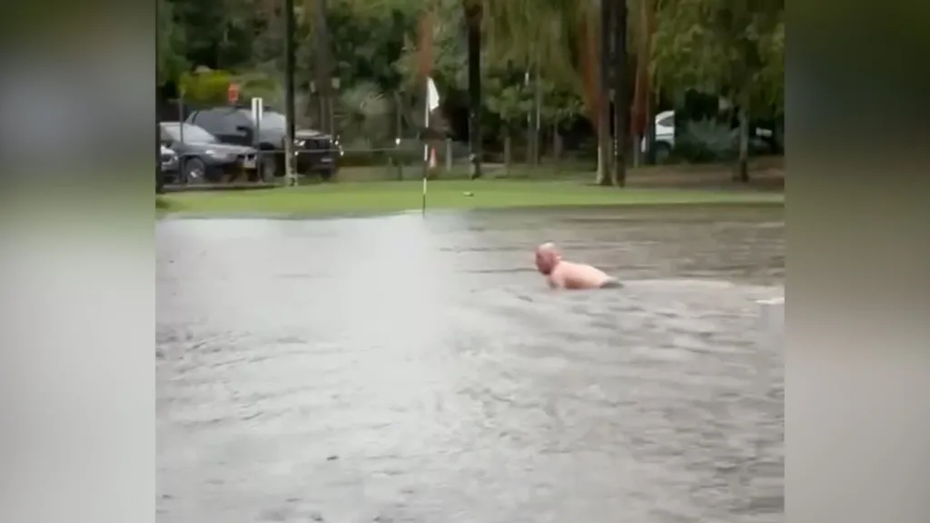 Man takes advantage of flooded Sydney golf course for impromptu swim